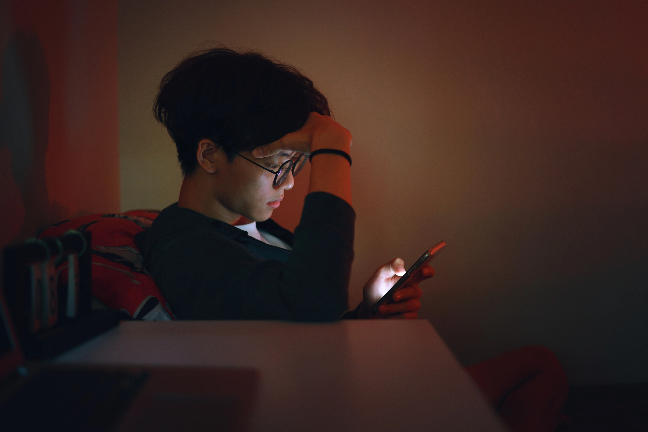 A young adult chatting with a therapist using his phone